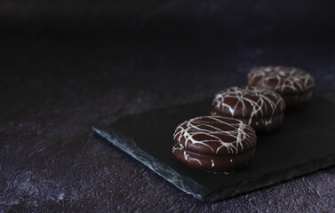 chocolate round cake in white glaze on a dark background