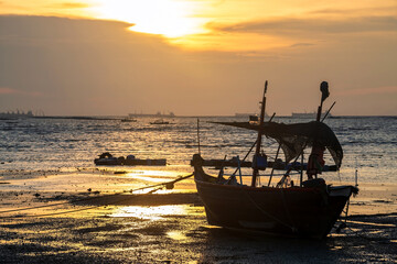 Silhouette fisherman boat on beach at sunset, Chonburi