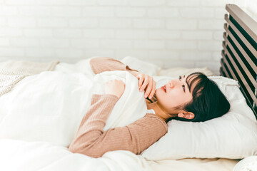 Fototapeta na wymiar ベッドルームで悪夢を見て眠れない不眠症の日本人女性 