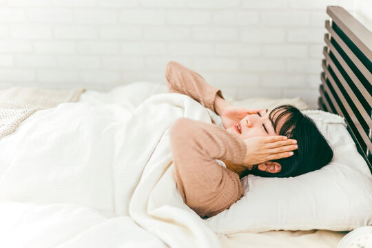 ベッドルームで悪夢を見て眠れない不眠症の日本人女性
