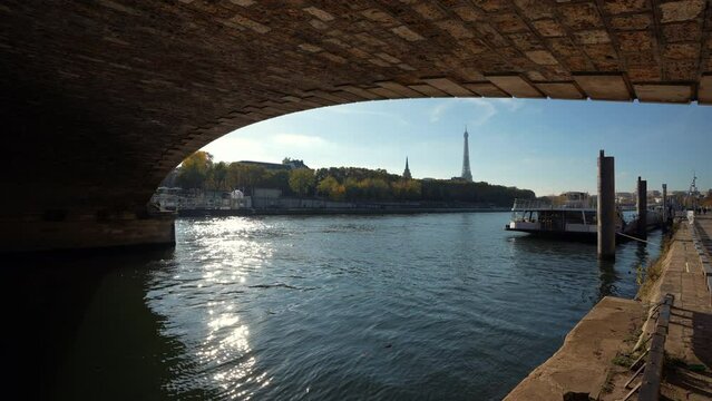 Travel to Paris. 4K wide angle video filmed under the bridge of Alexander next to Seine river, view to Eiffel Tower landmark. France, 2022.