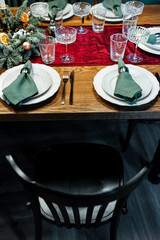 A beautiful and stylish table setting with a composition of fir branches with acorns and candles.