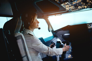 Woman pilot in the cockpit - obrazy, fototapety, plakaty