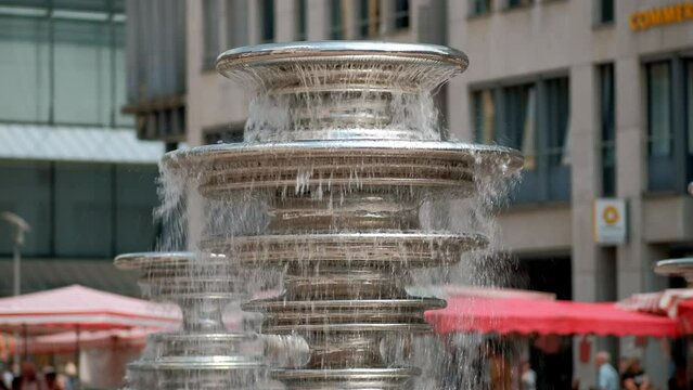 Close-up of a detail of the modern new waterfall fountain in Germany. The water flows on stainless steel metal disks.