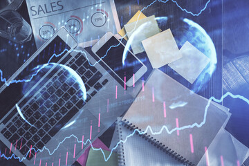 Financial market graph and top view computer on the desktop background. Multi exposure. Investment concept.