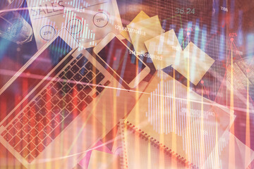 Financial market graph and top view computer on the desktop background. Multi exposure. Investment concept.