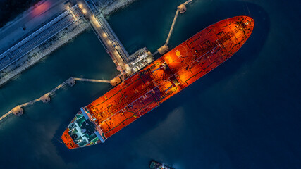 Aerial top view industrial crude oil fuel tanker ship at terminal industrial port,  Tanker ship unloading crude oil, Industry refinery fuel chemical import export business logistic and transportation.