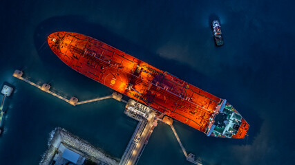 Aerial top view industrial crude oil fuel tanker ship at terminal industrial port,  Tanker ship unloading crude oil, Industry refinery fuel chemical import export business logistic and transportation.