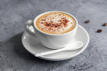 Creamy cappucino in cup on table