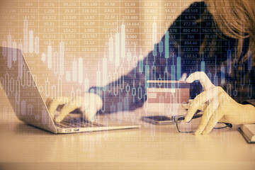 Double exposure of woman on-line shopping holding a credit card and financial graph drawing. Stock market E-commerce concept.