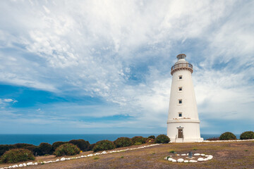 Fototapeta na wymiar Cape Willoughby active lighthouse viewed against blue sky with clouds on a bright day, Kangaroo Island, South Australia