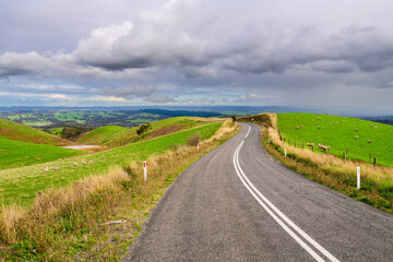 Winding road through Adelaide Hills farms during winter season, South Australia