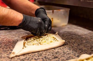 hand of chef baker making pide pizza at kitchen. The process of making pizza. cooking italian pizza