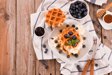 Waffles with blueberries and whipped cream.