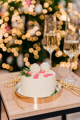 Festive Christmas cake in a package with a red bow and champagne glasses