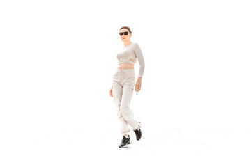 a full-length girl in light comfortable sportswear happily jumps and poses on a white background
