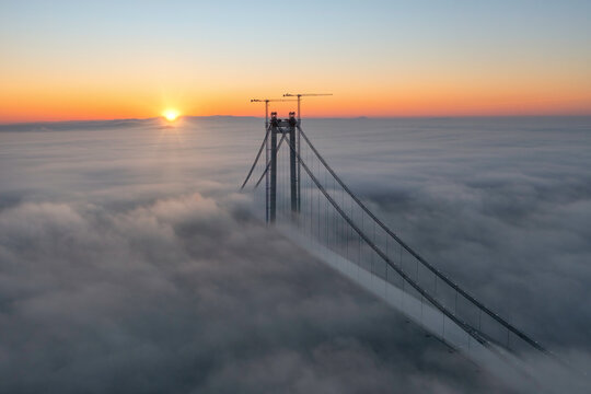 Panoramic aerial drone view from above of the suspended bridge over danube river, under construction, between Braila and Tulcea cities in Romania