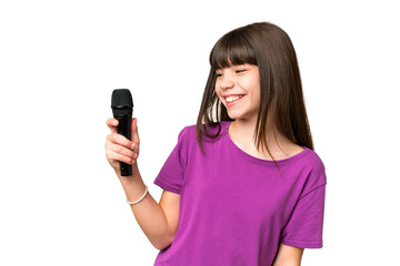 Little singer girl picking up a microphone over isolated background with happy expression