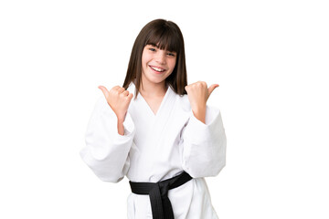Little Caucasian girl doing karate over isolated background with thumbs up gesture and smiling
