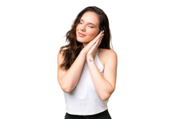 Young caucasian woman isolated over isolated background making sleep gesture in dorable expression