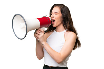 Young caucasian woman isolated over isolated background shouting through a megaphone