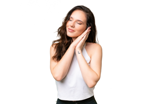 Young caucasian woman isolated over isolated background making sleep gesture in dorable expression