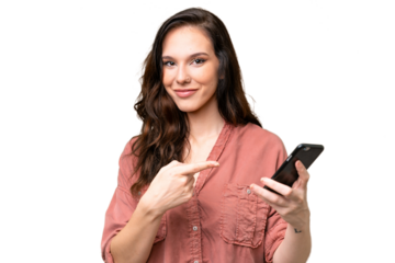 Young caucasian woman over isolated background using mobile phone and pointing it
