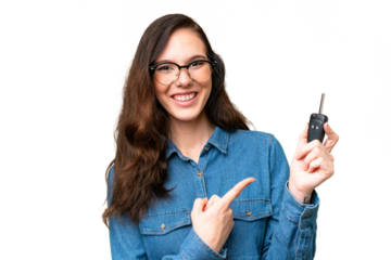 Young caucasian woman holding car keys over isolated background and pointing it