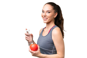 Young caucasian woman over isolated background with an apple and with a bottle of water