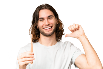 Young handsome man brushing teeth over isolated background proud and self-satisfied