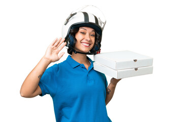 Pizza delivery Argentinian woman with work uniform picking up pizza boxes over isolated background saluting with hand with happy expression