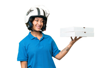 Pizza delivery Argentinian woman with work uniform picking up pizza boxes over isolated background...
