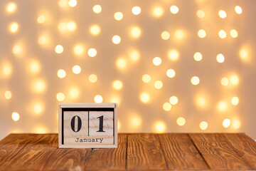 new year, wooden calendar january 1 on wooden background and lights background