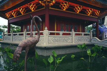 A Pagoda in the center of a Chinatown with a brown stork statue.