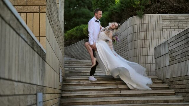 A couple in love, the bride and groom kiss in a beautiful pose. the bride makes a lunge on one leg