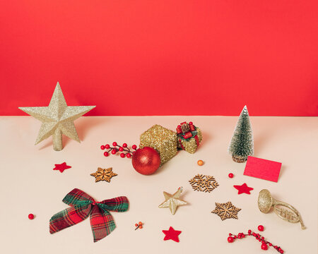 Creative winter pattern made of Christmas decoration, Gift box, snowflake and tree against red and beige background. Aesthetic New Year style. 