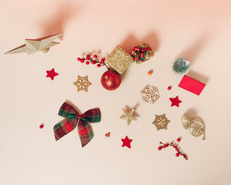 Creative winter pattern made of Christmas decoration, Gift box, snowflake and tree on beige background. Aesthetic New Year flat lay style. 