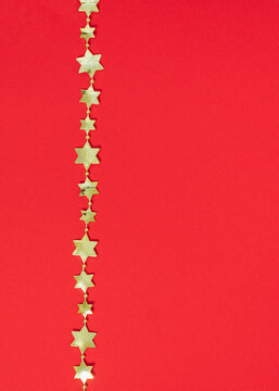 Christmas gold stars ornament on red background. Minimal shiny New Year concept. Winter season with copy space.