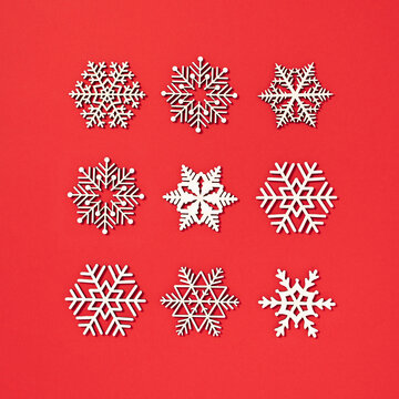 Pattern made of white snowflakes on red background. Minimal winter with snow concept. White Christmas flat lay idea.