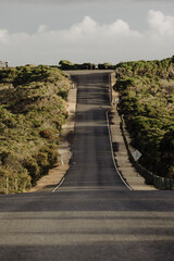 Road passing down through trees at Point Addis, Victoria, Australia. 