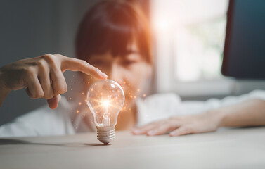 Creative new idea concept with innovation and inspiration. Woman holding light bulb.