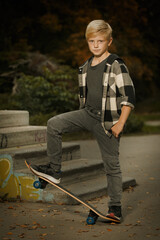 Young boy posing outdoor in skate park with skate board