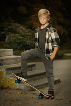 Young boy posing outdoor in skate park with skate board
