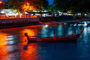 Pier at night with yellow lights on a background of blue sky
