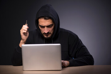 Young male hacker on grey background