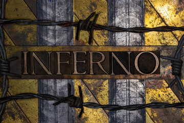 Inferno text with barbed wire on grunge textured copper and gold background