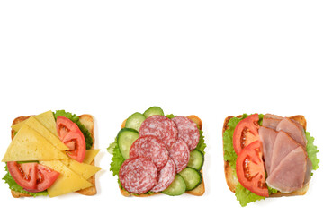 Homemade sandwich with ham and salami, cheese, tomato and cucumber. Sandwich isolated on white background.