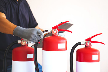 Close up fire extinguisher and firefighter checking pressure gauge level for protection and prevent and safety rescue and use of equipment on fire training concept.