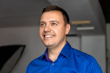 Energetic millennial handsome man wearing blue shirt standing with big smile on face, open mouth...