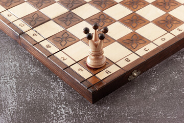 White chess Queen piece hand carved in wood on handmade board.Business strategy, tactics concept